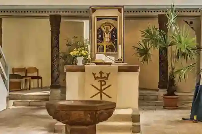 Innenraum der Dorfkirche Haindorf mit Blick auf Altar, Taufstein und Bepflanzung.